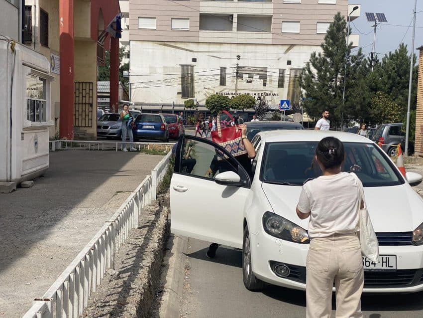 Edukatorja e mbulon kokën me çantë pas intervistimit